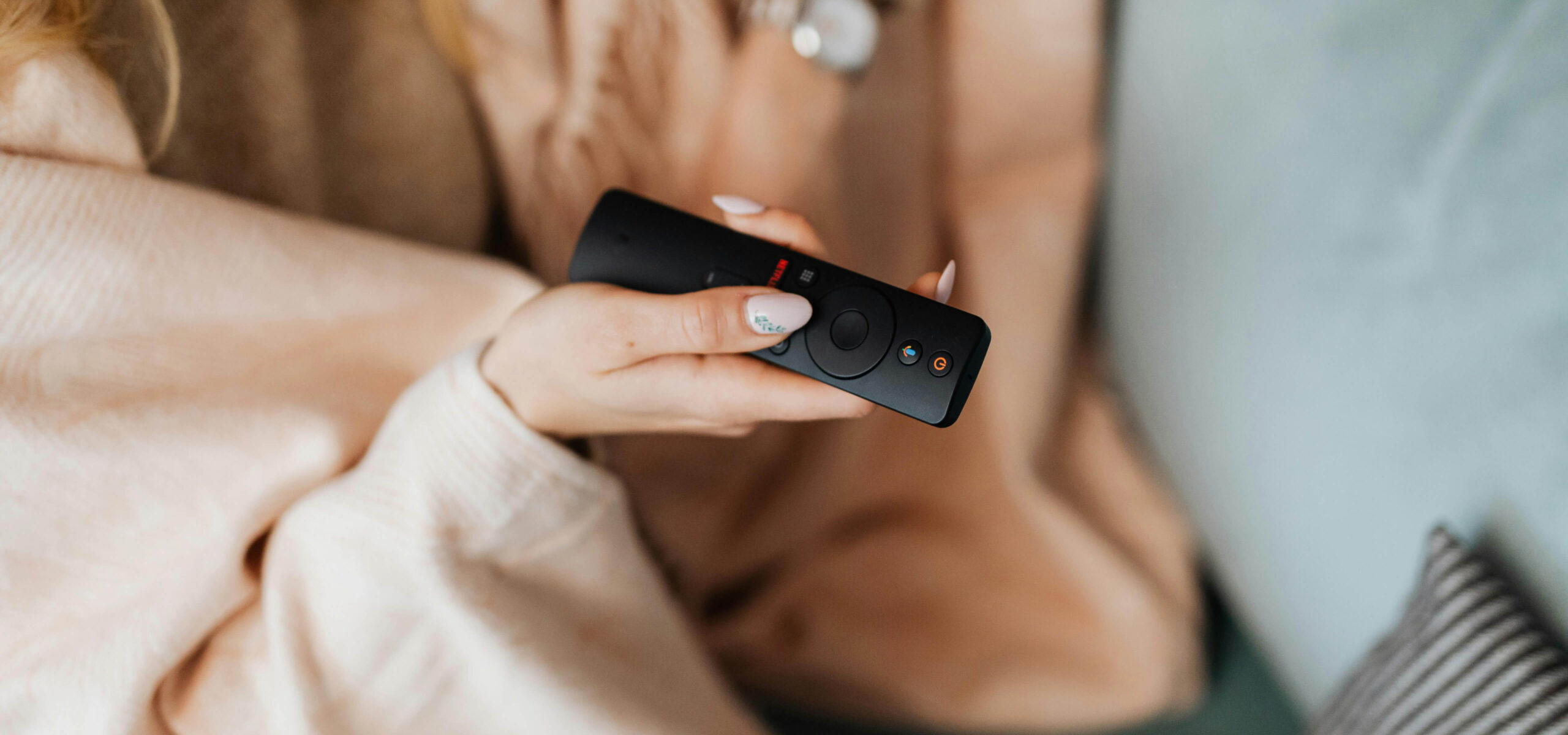 A person holding a smart tv remote control